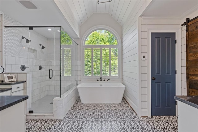 bathroom with a stall shower, vanity, a soaking tub, lofted ceiling, and tile patterned flooring