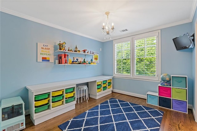 playroom with wood finished floors, a notable chandelier, heating unit, and visible vents