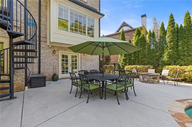 view of patio / terrace with stairway, outdoor dining space, an outdoor fire pit, and french doors