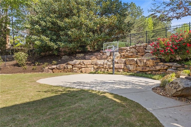 view of sport court with basketball court, a yard, and fence