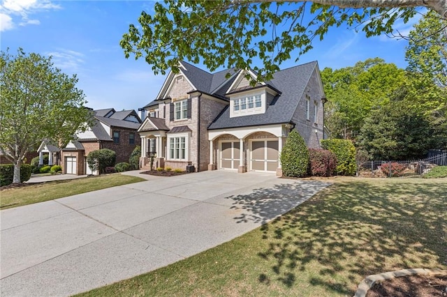 view of front of house featuring an attached garage, a front lawn, driveway, and fence