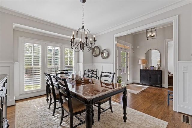 dining room with a decorative wall, a chandelier, visible vents, and plenty of natural light