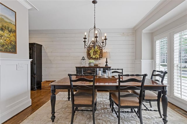 dining area with ornamental molding, an inviting chandelier, and a healthy amount of sunlight