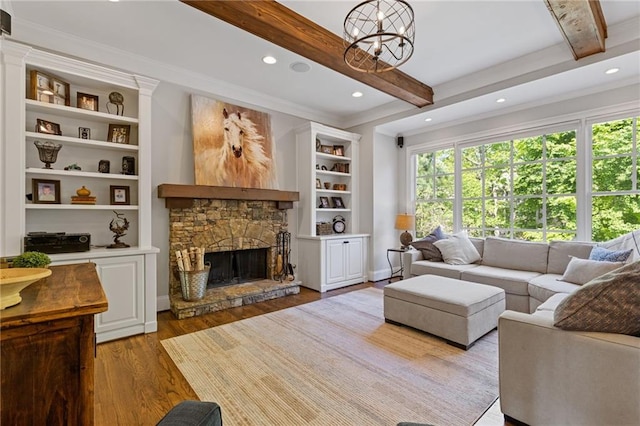 living area with wood finished floors, a stone fireplace, crown molding, and plenty of natural light