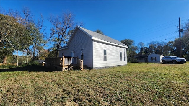 view of side of property with a lawn and a deck