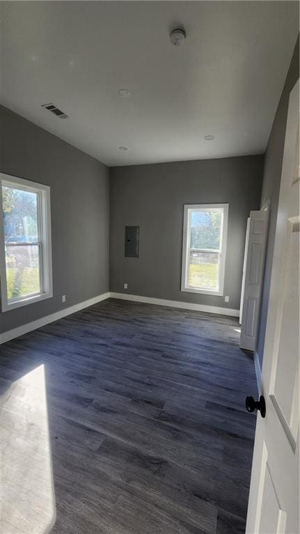 empty room featuring dark hardwood / wood-style flooring and electric panel