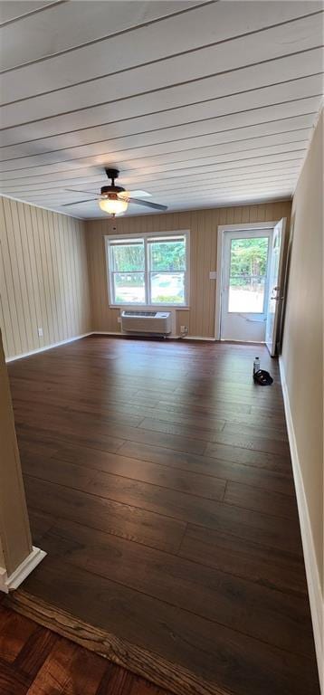 spare room with ceiling fan, a wall mounted AC, wood finished floors, and baseboards