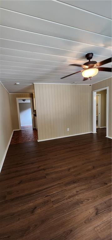 empty room featuring dark wood-style floors and a ceiling fan