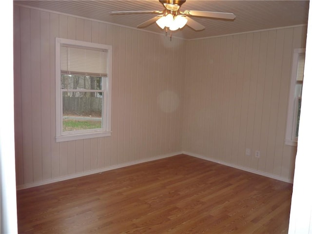 spare room with ceiling fan, baseboards, and wood finished floors