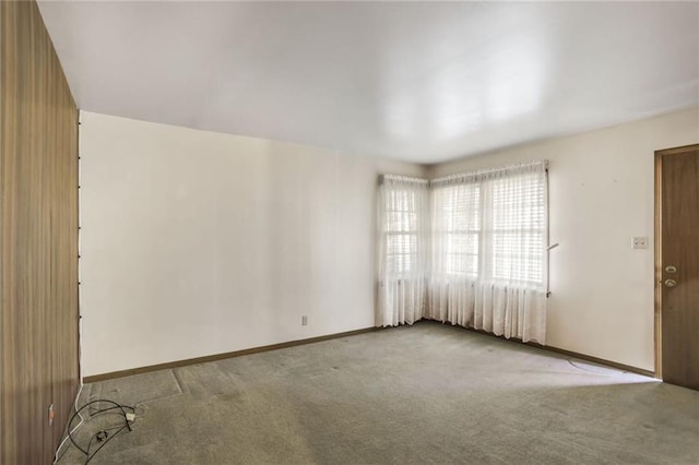 carpeted empty room featuring baseboards