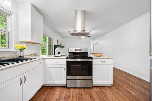 kitchen with white cabinetry, island range hood, stainless steel range with electric cooktop, and wood finished floors