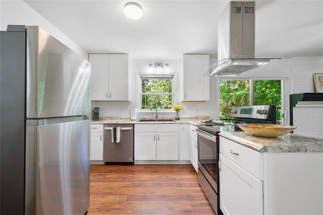 kitchen featuring dark wood-style flooring, a sink, white cabinetry, island range hood, and appliances with stainless steel finishes