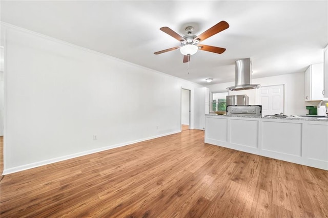 unfurnished living room with a ceiling fan, baseboards, and light wood-style flooring