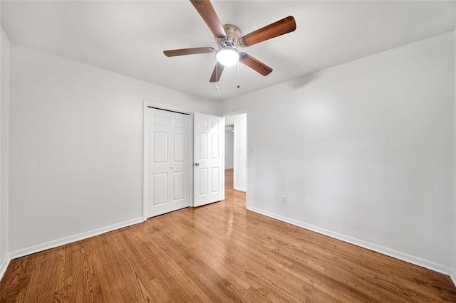 unfurnished bedroom with baseboards, a closet, ceiling fan, and wood finished floors