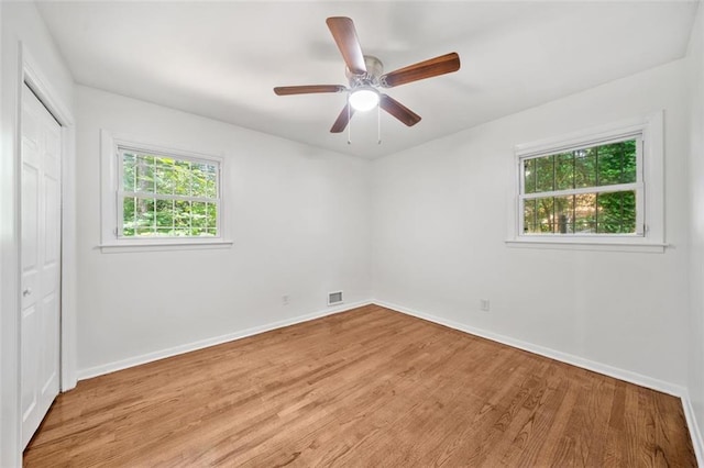 unfurnished room featuring light wood-type flooring, baseboards, and ceiling fan