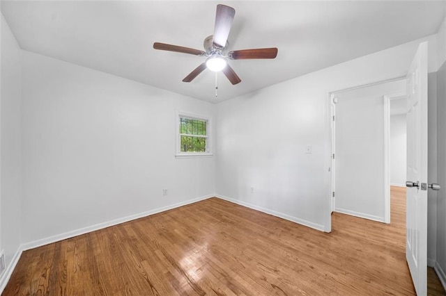 unfurnished room with baseboards, a ceiling fan, and wood finished floors