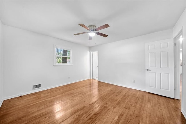 unfurnished bedroom with baseboards, ceiling fan, visible vents, and wood finished floors