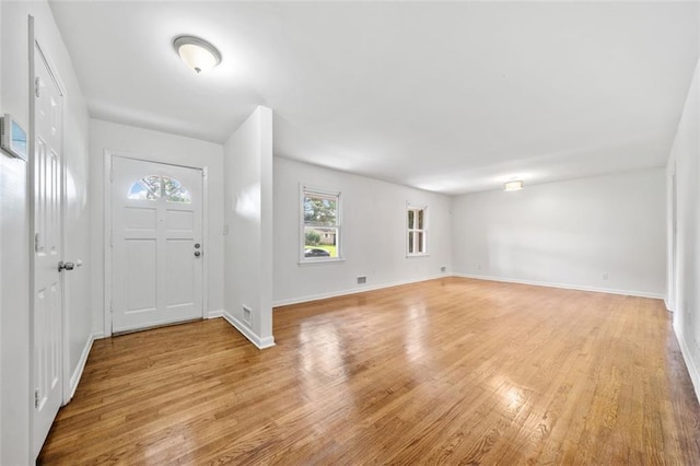 foyer entrance featuring light wood finished floors and baseboards