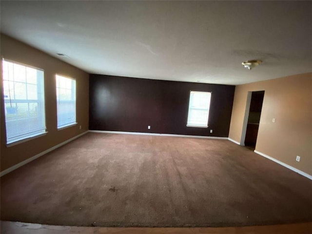 carpeted spare room featuring a wealth of natural light