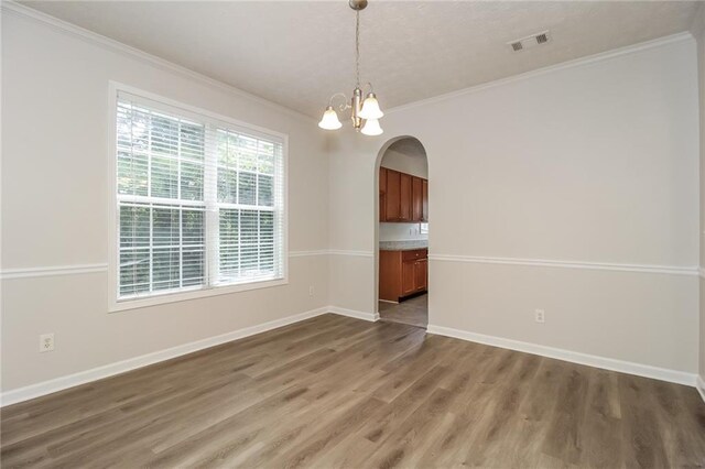 194 Wilhelmina Dr, Austell, GA 30168 - unfurnished dining area with arched walkways, wood finished floors, ornamental molding, baseboards, and a chandelier