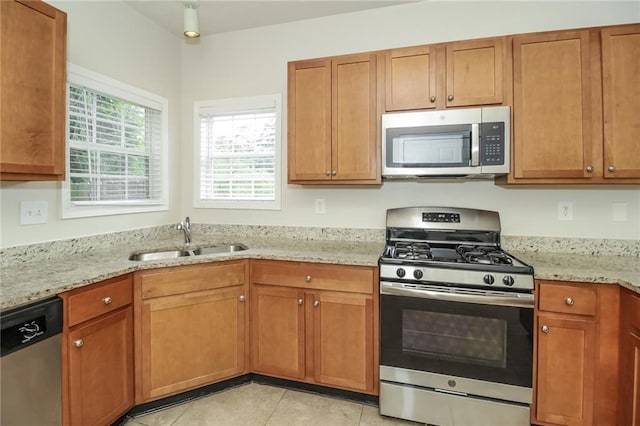 194 Wilhelmina Dr, Austell, GA 30168 - kitchen featuring stainless steel appliances, a sink, light stone counters, and brown cabinets