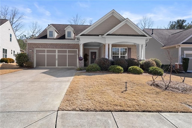 craftsman-style house featuring a garage, concrete driveway, and brick siding