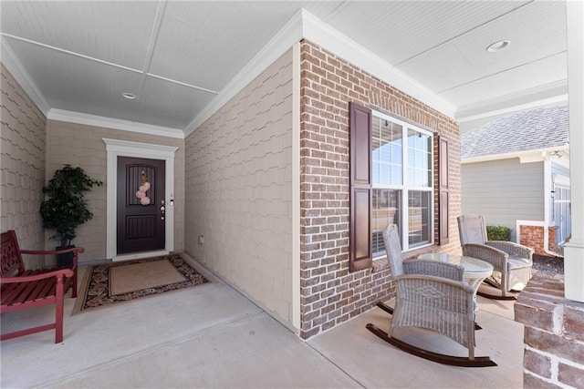 entrance to property with covered porch and brick siding