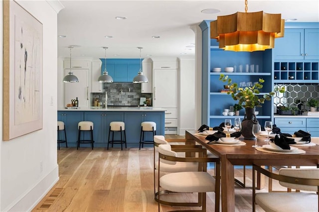 dining space featuring light wood finished floors, baseboards, and recessed lighting