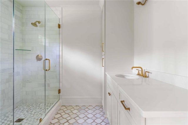 bathroom featuring a shower stall, baseboards, and vanity