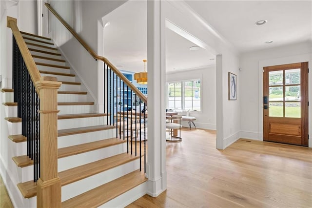 foyer entrance featuring an inviting chandelier, light wood-style flooring, stairway, baseboards, and recessed lighting