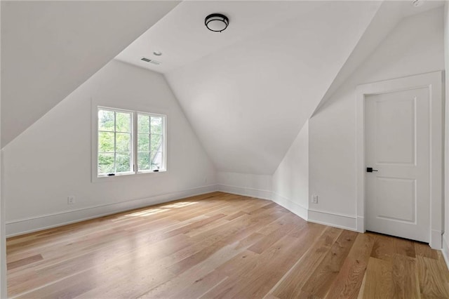 bonus room featuring vaulted ceiling, baseboards, visible vents, and wood finished floors