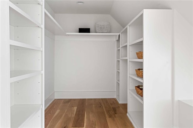 spacious closet with wood finished floors and lofted ceiling