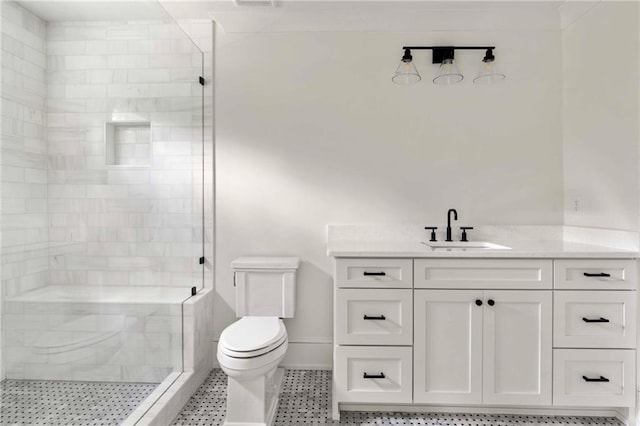 full bathroom featuring toilet, tiled shower, vanity, and baseboards