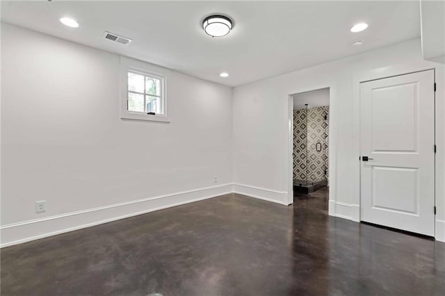 unfurnished room featuring finished concrete floors, visible vents, baseboards, and recessed lighting