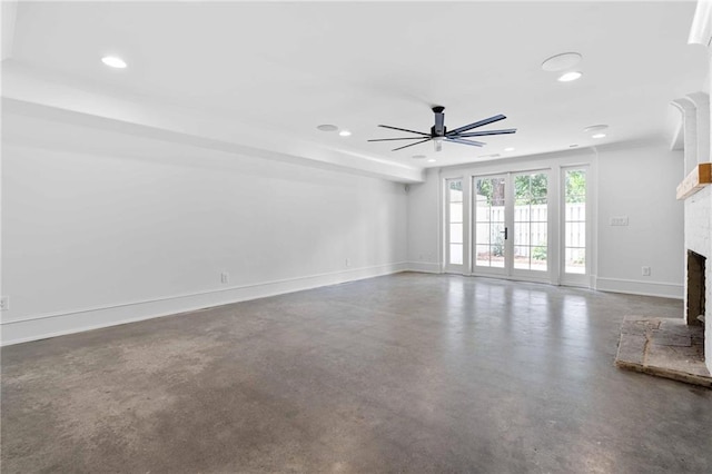 unfurnished living room featuring recessed lighting, a ceiling fan, a fireplace with raised hearth, and concrete floors