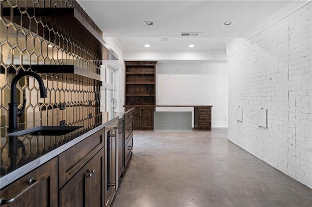 interior space with a sink, finished concrete floors, visible vents, recessed lighting, and brick wall
