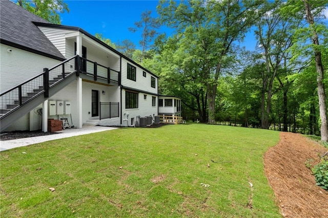 view of yard with central AC and stairs
