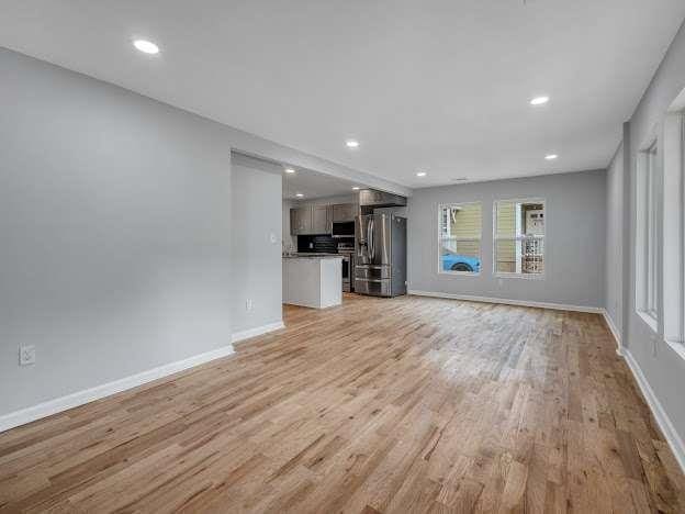 unfurnished living room with light wood-style floors, baseboards, and recessed lighting