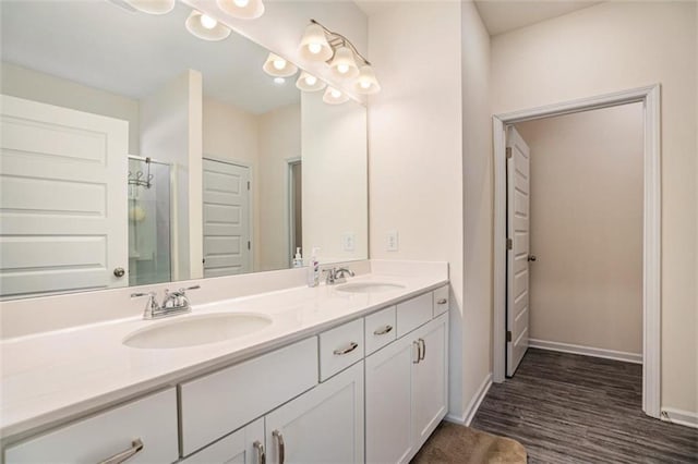 bathroom with a shower with shower door, vanity, and hardwood / wood-style flooring