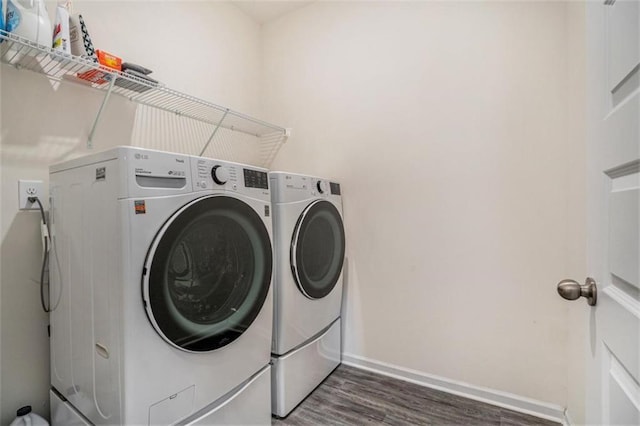 laundry area with washing machine and dryer and dark wood-type flooring