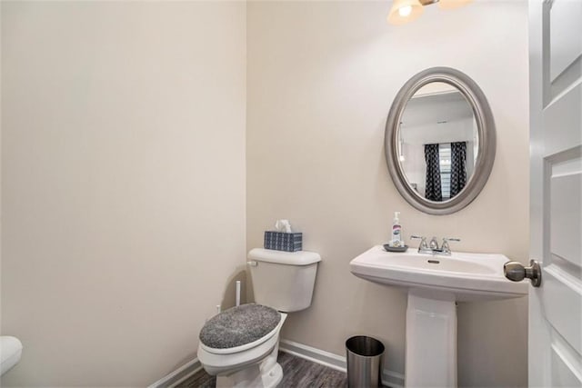 bathroom with hardwood / wood-style floors and toilet