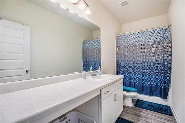 full bathroom with toilet, shower / tub combo, hardwood / wood-style flooring, and vanity