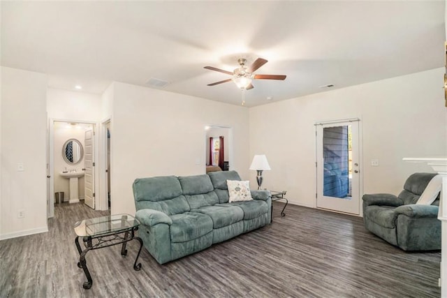 living room with ceiling fan and dark wood-type flooring