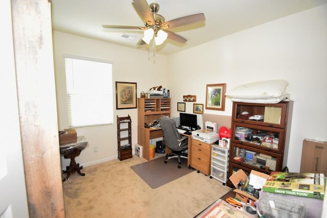 carpeted home office featuring ceiling fan