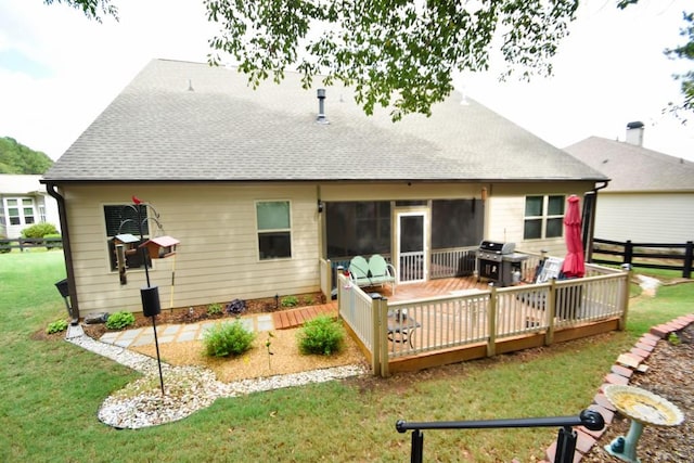 rear view of house with a deck and a yard