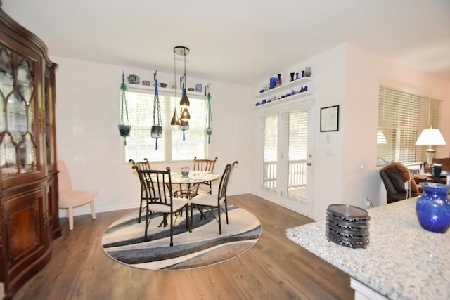 dining room with an inviting chandelier and dark wood-type flooring