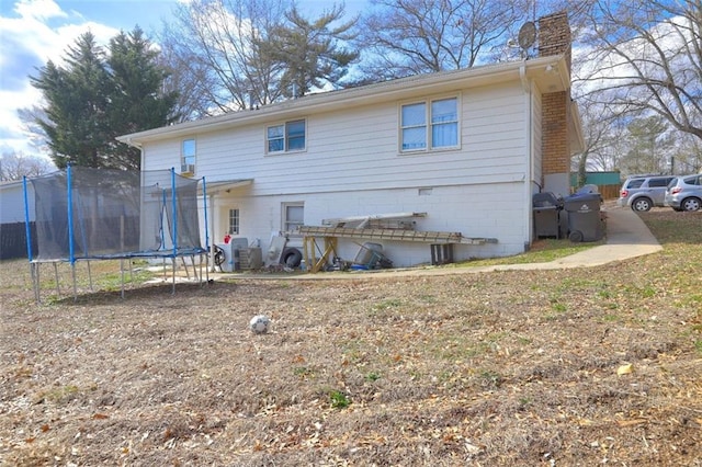 rear view of property with a trampoline