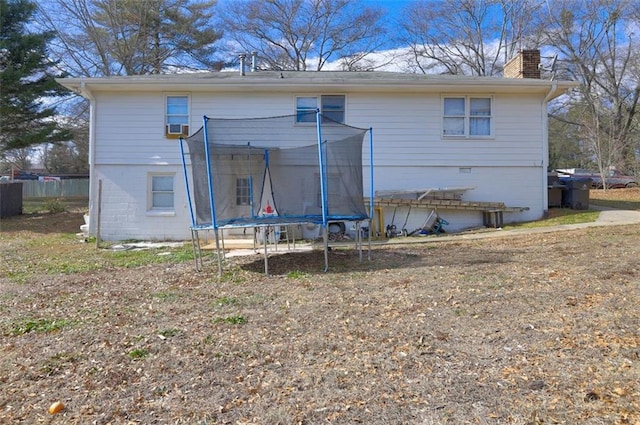 back of property featuring a trampoline