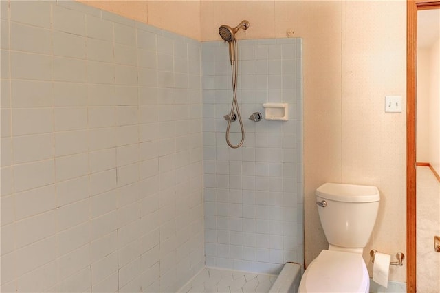 bathroom featuring toilet and tiled shower