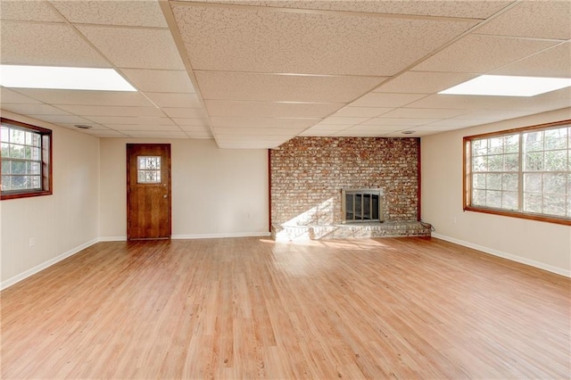 unfurnished living room with a healthy amount of sunlight, a fireplace, and wood finished floors